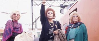 Three women in the 1970s standing on train platform